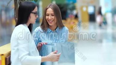 两位美丽的年轻女士在商场购物后休息和讨论一些事情。